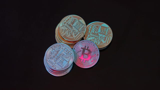 A detailed image showcasing a stack of Bitcoin cryptocurrency coins on a black background.