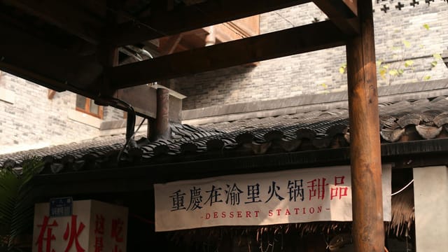 Entrance to a traditional dessert shop with Chinese signage and rustic architecture.