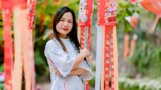Portrait of a young woman in traditional attire amidst festive Lunar New Year decorations.