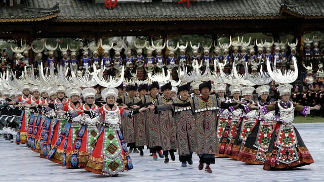 Miao dancers in traditional attire perform during a festive celebration in Leishan County.