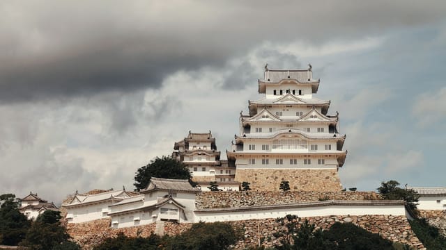 Beautiful view of Himeji Castle in Japan, showcasing classic architecture under clouded skies.