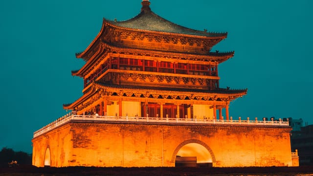 Majestic view of the illuminated Bell Tower in Xi'an, China against a twilight sky.