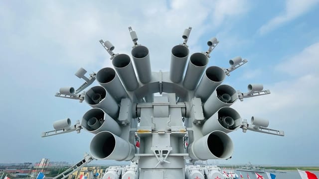 Close-up of naval artillery on a warship at Tianjin Harbour, China, showcasing military might.