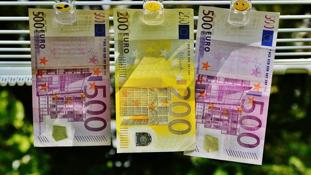 Euro currency notes clipped to a line, symbolizing finance concepts like money laundering or savings.