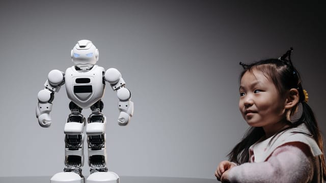Young Asian girl interacts with a high-tech toy robot, showcasing innovation and curiosity.