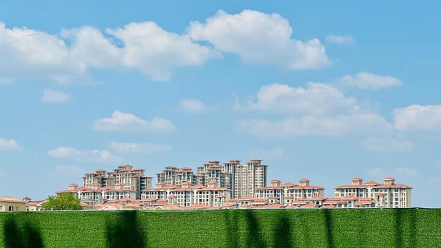 View of a modern apartment complex under a clear blue sky in Tianjin, China.