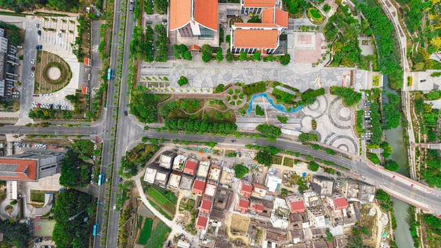 Colorful aerial view of a cityscape showcasing roads, buildings, and green spaces.