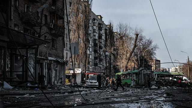 A war-damaged street in Kyiv, Ukraine, showing destruction and chaos.