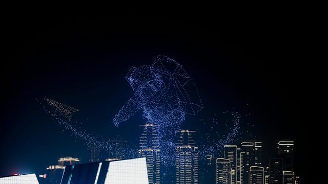 Breathtaking drone light show forming astronaut shape above city skyline, showcasing innovation.