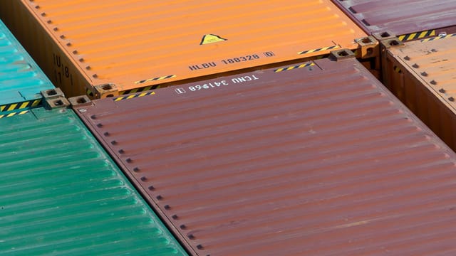 Illustrative image: Aerial view of vibrant cargo containers arranged in a pattern, emphasizing logistics and transportation.