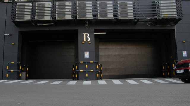 Modern garage entrance with air conditioning units above and a zebra crossing in Kyiv, Ukraine.