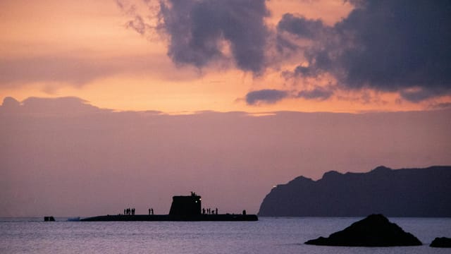 A submarine silhouetted against a stunning sunset sky over the sea near Cartagena, Spain.