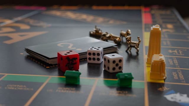 A detailed view of a board game with dice, tokens, and landmarks on a playing board.