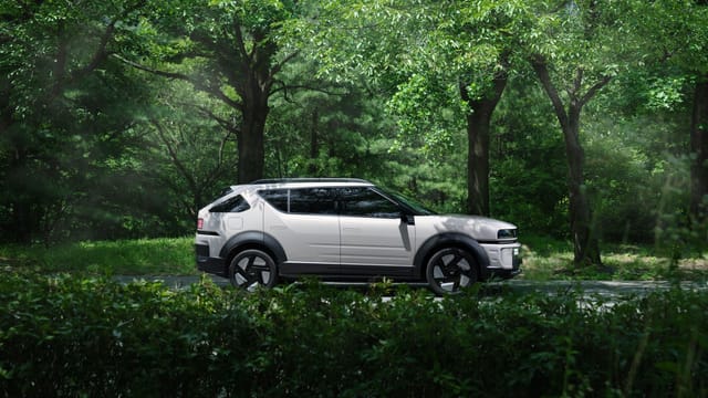A modern electric SUV parked in a serene forest, blending nature and technology.