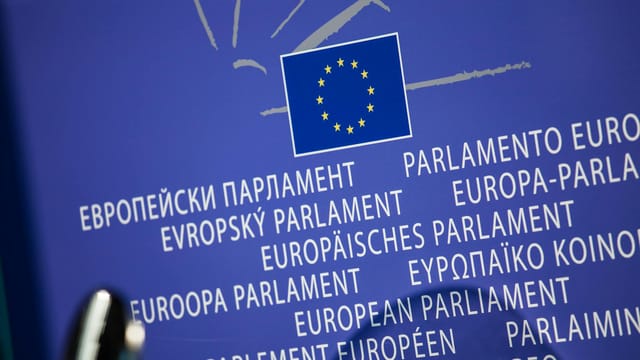 Close-up view of the European Union flag with multilingual text showing European Parliament.