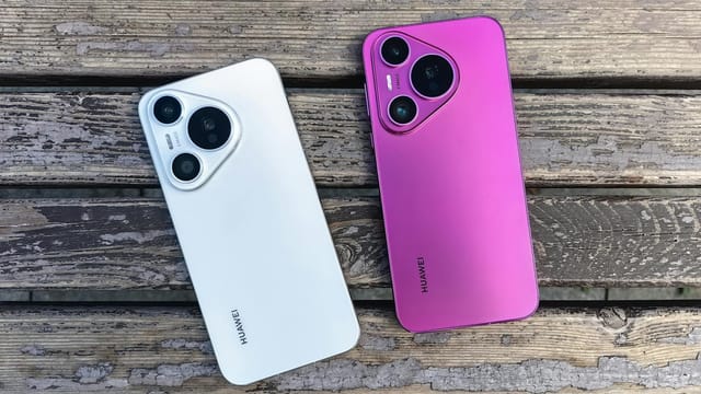 Two Huawei smartphones in white and pink on rustic wooden slats.