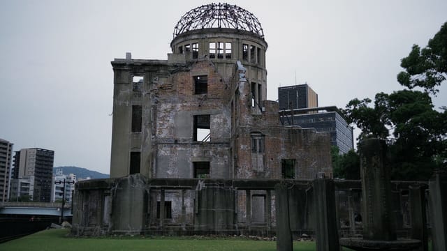 Historic Hiroshima Atomic Bomb Dome with modern city backdrop.