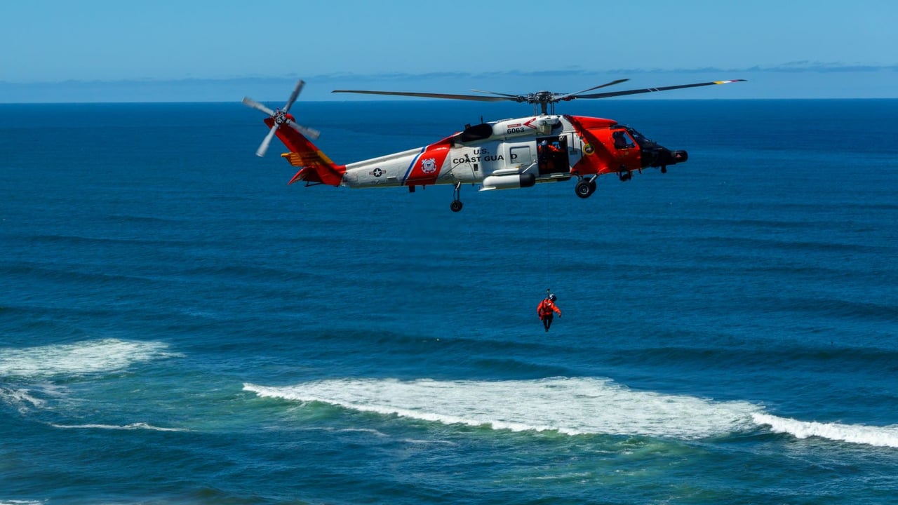 Dramatic coast guard helicopter rescue operation over the ocean waves.