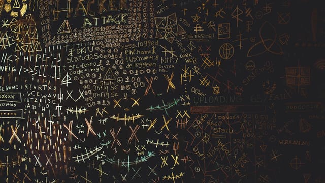 Complex chalkboard art featuring hacking symbols, codes, and geometric patterns.