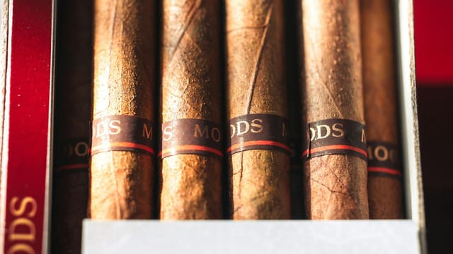 Detailed view of premium cigars with visible textures and labels in a box.