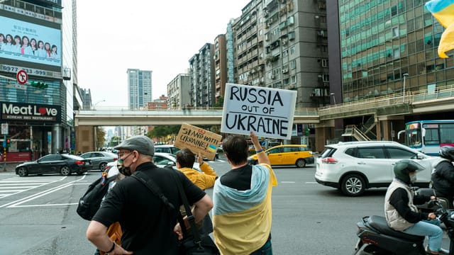 Protesters in the city holding signs against Russia's actions in Ukraine.