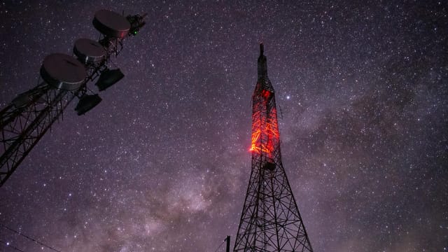 Stunning capture of a communication tower under a star-filled night sky.