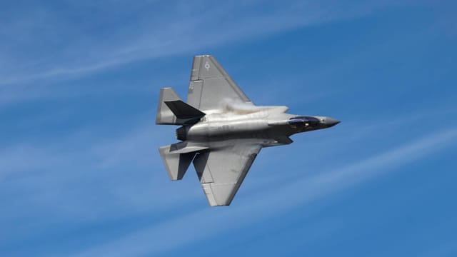 F-35 Lightning II jet soaring above Kernville, CA against a clear blue sky, showcasing its sleek design.