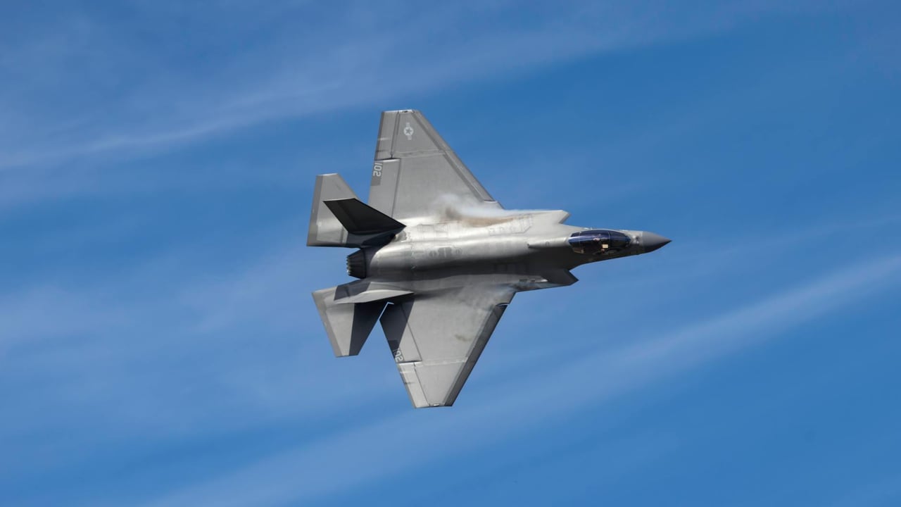 F-35 Lightning II jet soaring above Kernville, CA against a clear blue sky, showcasing its sleek design.