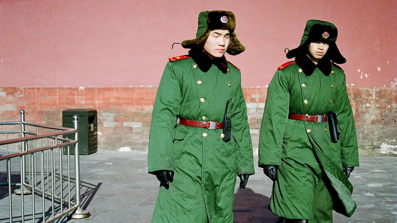 Two military officers in green winter uniforms walking outdoors during the day.