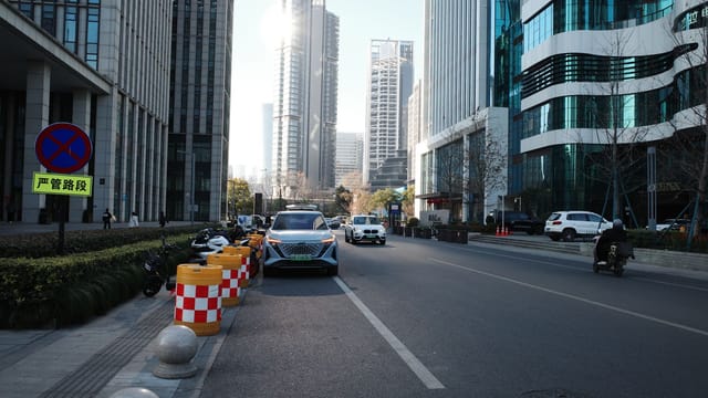 Urban street view with modern skyscrapers and vehicles in daylight.