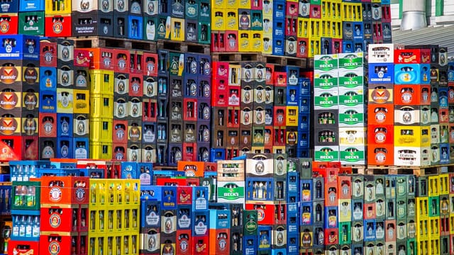 A vibrant display of beer crates stacked in a warehouse, showcasing various brands.