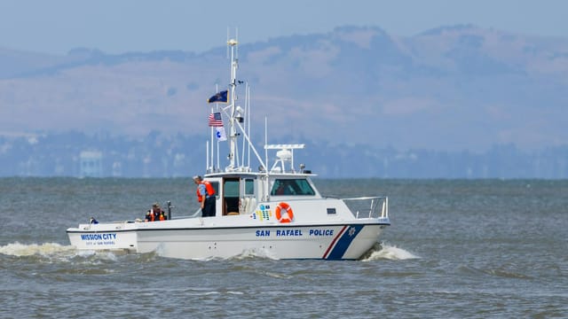 San Rafael police boat Mission City patrolling coastal waters under a clear sky.