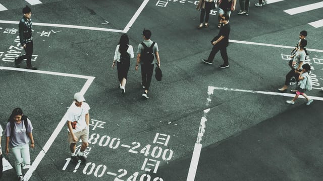 Aerial view of people crossing a busy intersection in Taipei's city center.