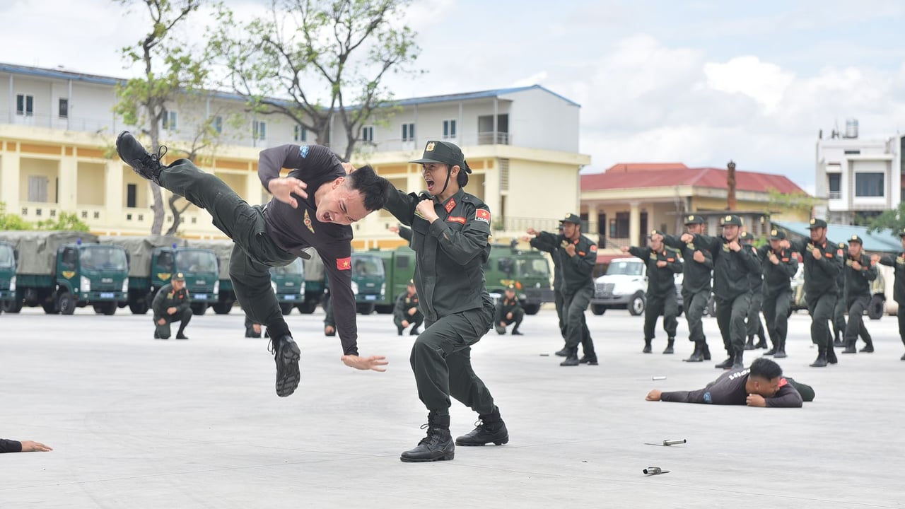 Military personnel engaging in a dynamic hand-to-hand combat training exercise outdoors.
