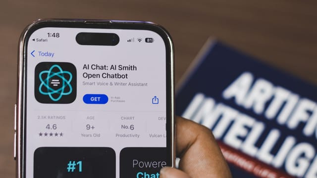 Hand holding a smartphone with AI chatbot app, emphasizing artificial intelligence and technology.