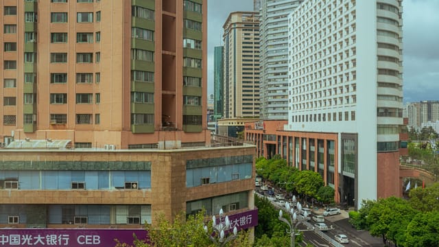 Panoramic view of a busy city street lined with modern high-rise buildings.