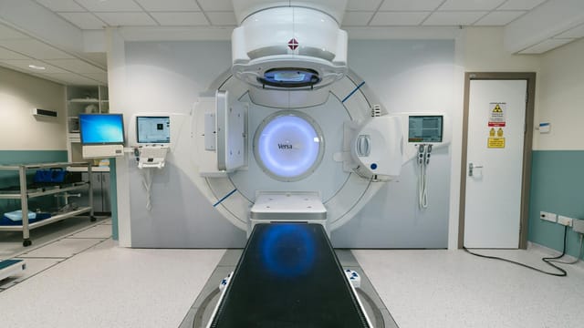 A modern radiotherapy machine in a hospital setting used for cancer treatment.