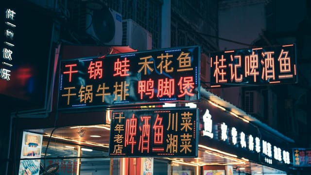 Chinese neon signs illuminate a night market street in Guilin, Guangxi, China, showcasing vibrant local culture.