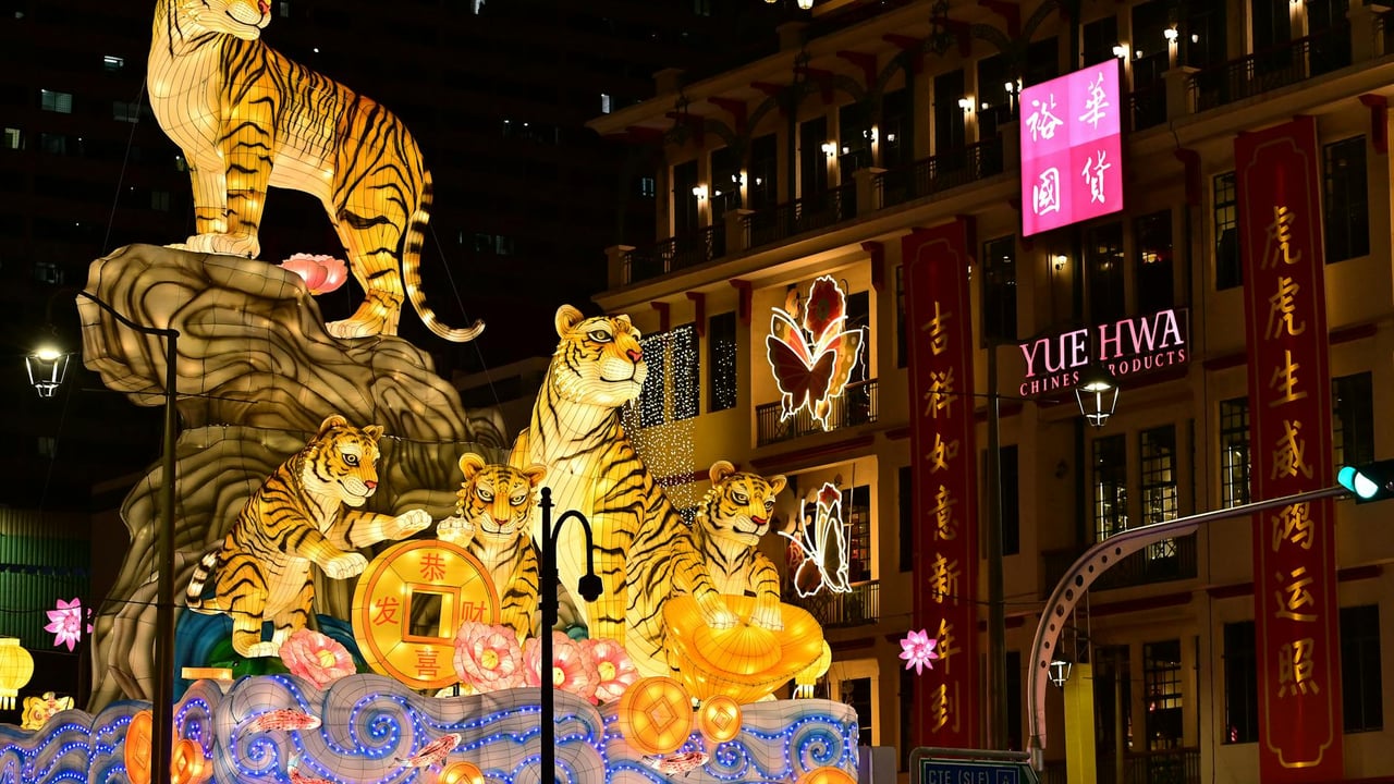 Colorful tiger lanterns and decorations illuminate the streets of Chinatown during a festive night.