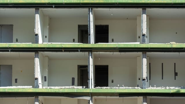 Close-up view of a partially demolished urban building showing exposed concrete and empty rooms.