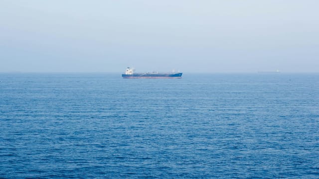 A large cargo ship sails on the tranquil ocean near Vũng Tàu, Vietnam, symbolizing global commerce.