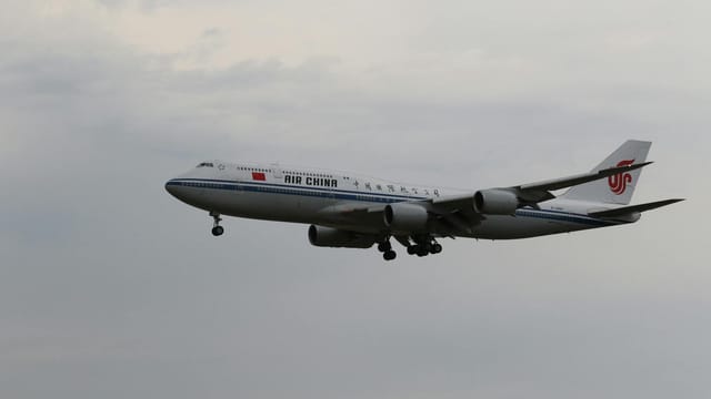 Air China aircraft approaching landing at Frankfurt airport, highlighting travel and aviation.