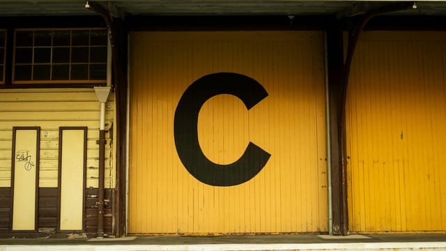 Yellow warehouse door marked with large 'C', vintage style in Fremantle.
