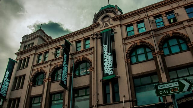 Low angle view of the historic Grace Bros building in Broadway, Sydney under cloudy skies.