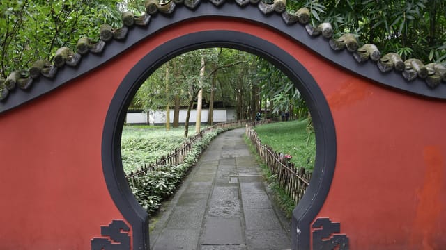 Explore serenity through a traditional Chinese garden archway at Du Fu Thatched Cottage in Chengdu.
