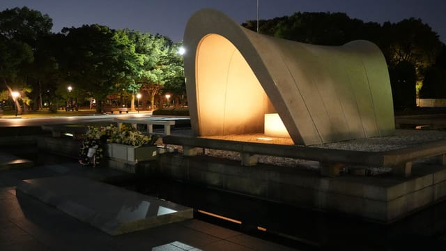 Illuminated Hiroshima Peace Memorial Park captured at night, serene and hauntingly beautiful.