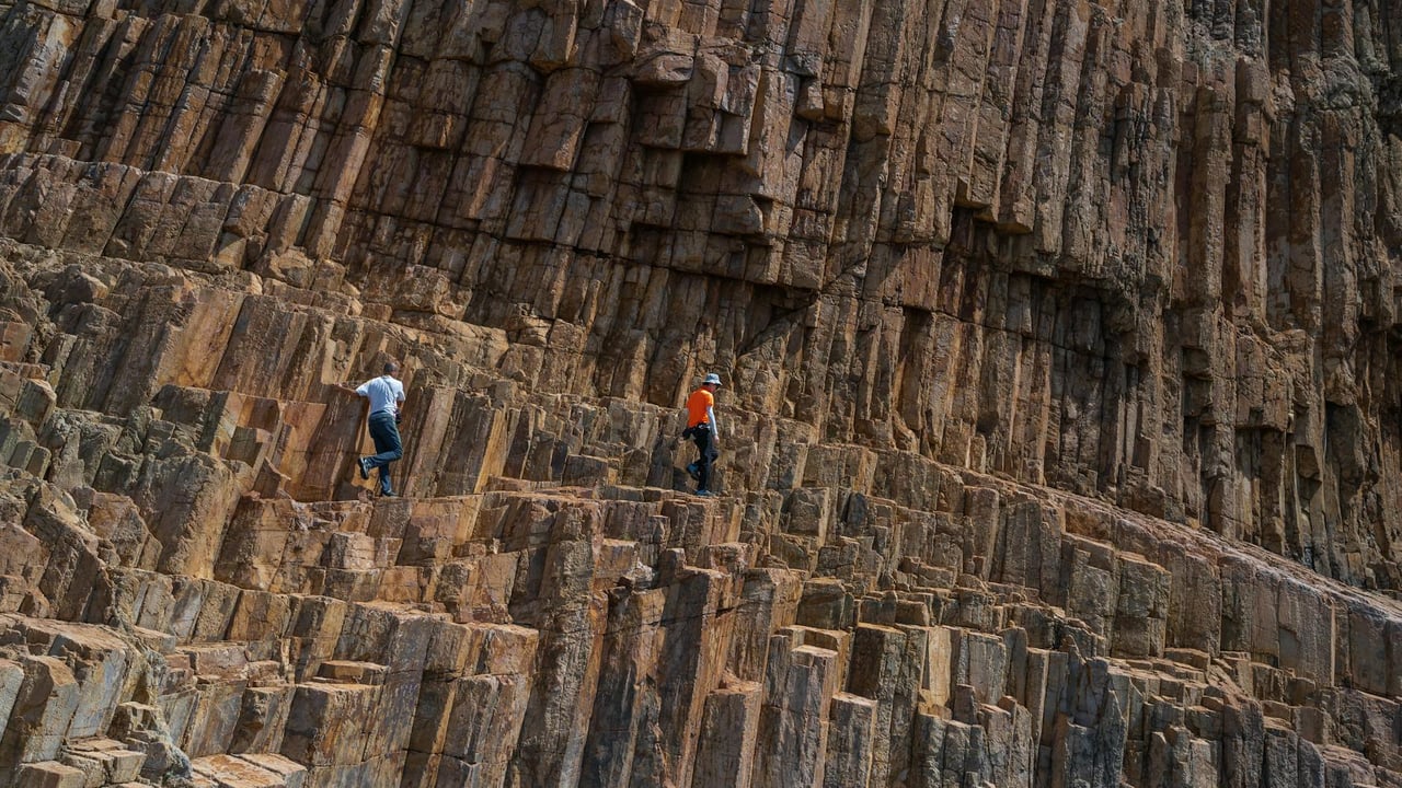Adventurers scaling unique volcanic rock formations outdoors.