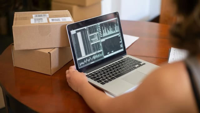 Small business owner managing online orders from a laptop in Portugal.