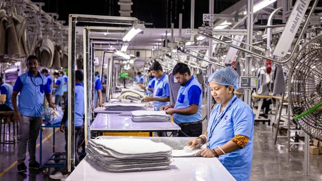 Blue-collar staff in a textile factory focusing on garment production and quality control.