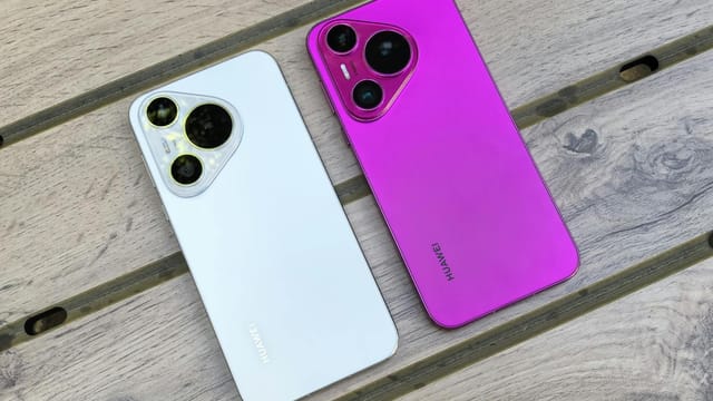 Two Huawei smartphones in white and pink on a wooden table with no people.